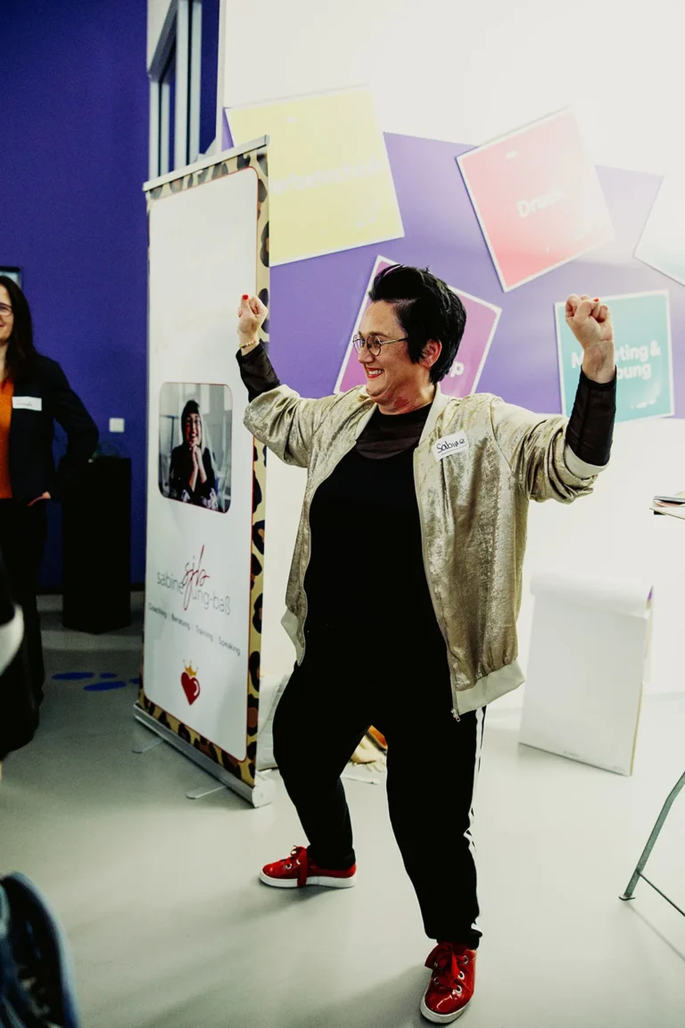 Sabine, die Führungskräfte coacht und Seminare zu Schlagfertigkeit gibt, macht eine Powerpose.